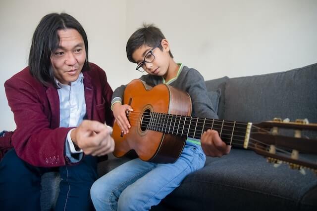 מורה למוזיקה מלמד ילד לנגן