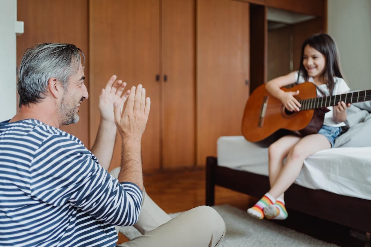 ילדה מנגנת גיטרה לאבא שלה
